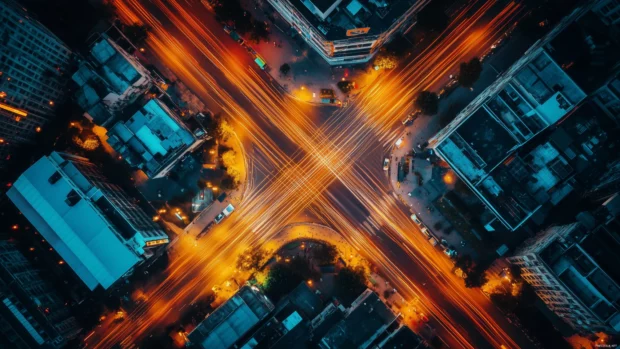 Night city intersection with car light trails in long exposure.