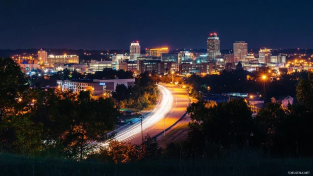 Nighttime City skyline as seen from a hilltop view.