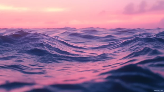 Ocean waves reflecting early sunrise light with pink sky.