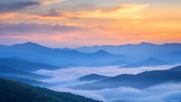 Peaceful cloud layers floating over mountain peaks during sunrise, perfect Sunrise Desktop Wallpaper with Clouds.