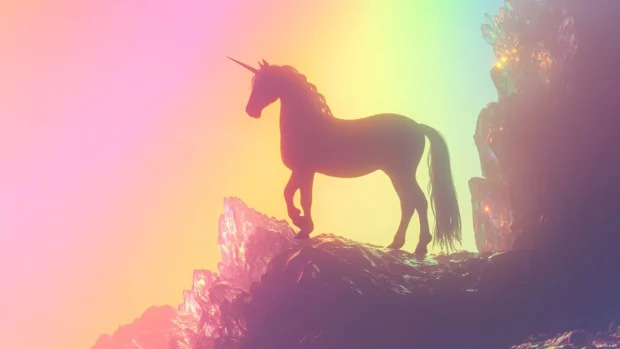 Rainbow Unicorn wallpaper showing a unicorn standing on a crystal cliff with rainbow light shining behind.