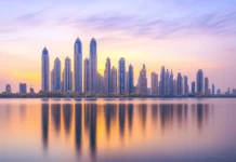 Serene coastal skyline, golden hour buildings, shimmering water reflection.