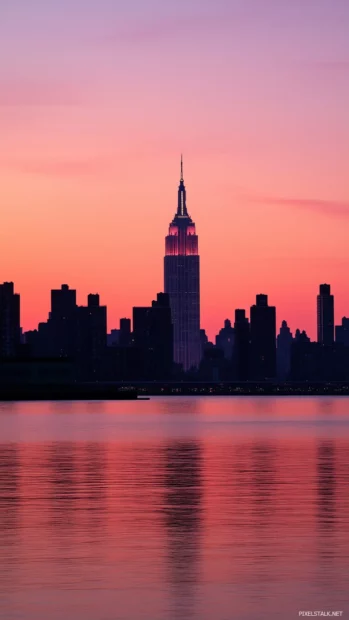 Silhouette of New York skyline under a calming pink and orange sunset.