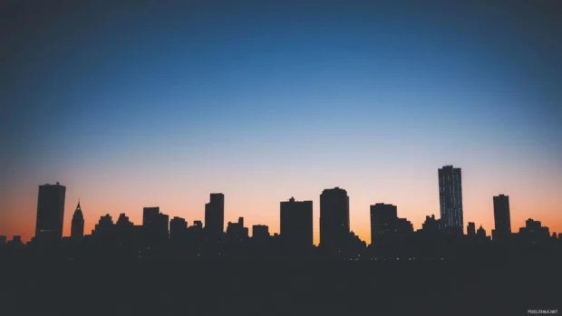 Silhouette of a city skyline at dusk with a gradient sky.