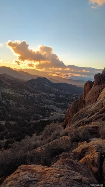 Sunrise climbs over rocky peaks and glowing clouds.
