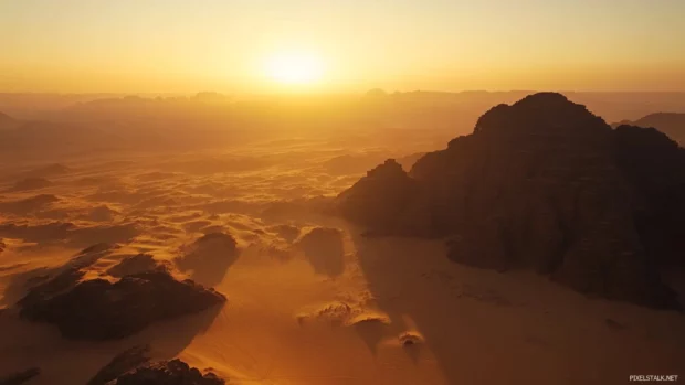 Sunrise paints soft patterns on desert dunes.