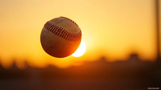 Sunset baseball stadium background, Baseball mid air with glowing sunset in background.