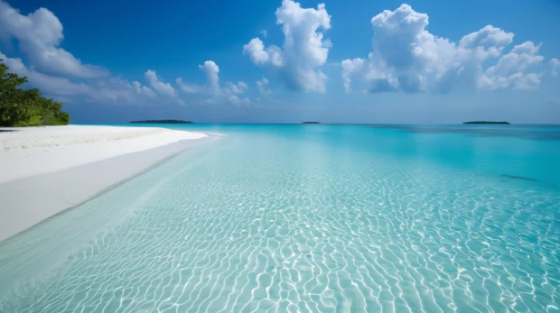 Turquoise water beach with clear waves and white sand.