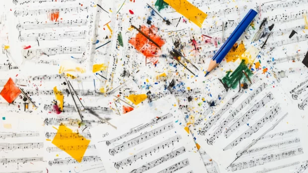 Vigorous overhead view multiple sheets of music creative pattern scattered pencil marks and erasers showcasing process of composition.