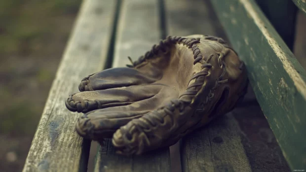 Vintage baseball wallpaper Macbook, An old leather glove holding a baseball on a wooden bench.