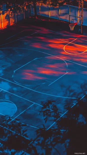 A basketball court bathed in twilight glow with dreamy shadows.
