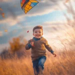 A boy with a playful smile, running through a field of tall grass with a colorful kite soaring in the sky.