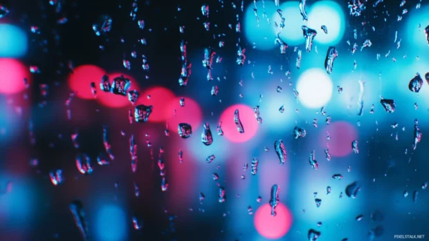 A close up of raindrops on a windowpane, ideal for Windows 10 lock screen background.