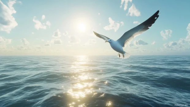 A seagull soaring above the glistening ocean under a bright afternoon sky.