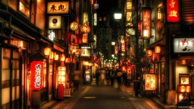 A vibrant street in Tokyo at night, glowing with neon signs and bustling crowds.