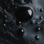 Abstract black ink drops floating in dark water.