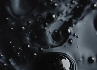 Abstract black ink drops floating in dark water.