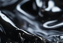 Abstract black liquid ripples forming sharp edgy patterns.