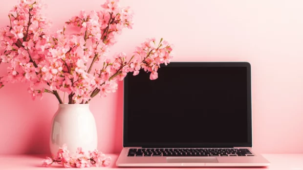 Aesthetic girly pink laptop workspace with minimalist decor.