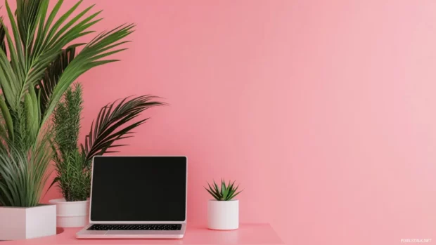 Aesthetic girly pink laptop workspace with minimalist decor.
