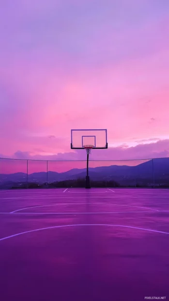 Basketball court washed in pink and purple dusk light, peaceful and serene.