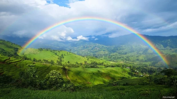 Beautifull rainbow arching over green countryside.