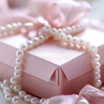 Beautifully wrapped pink gift box with satin ribbon and pearls.
