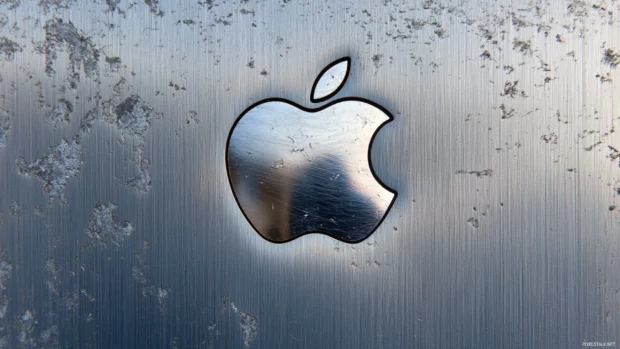 Classic bitten Apple emblem resting on sleek metallic surface, Mac style.