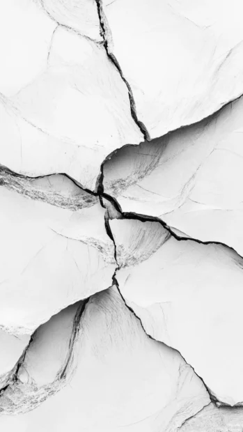 Cracked display iPhone lock screen wallpaper showing deep fracture lines.