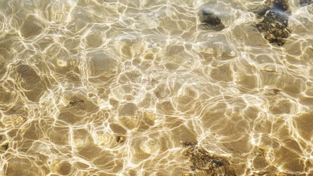 Crystal clear water showing sandy seabed, suitable as minimalist ocean desktop background.