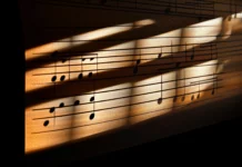 Detailed music notes on musical staff under sunlight with soft window shadows.