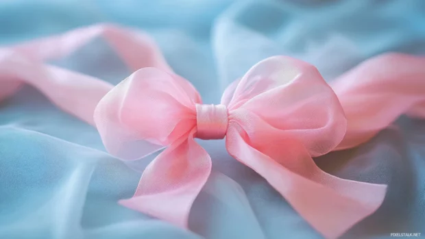 Elegant pink silk ribbon tied into a beautiful bow, soft luxury texture.
