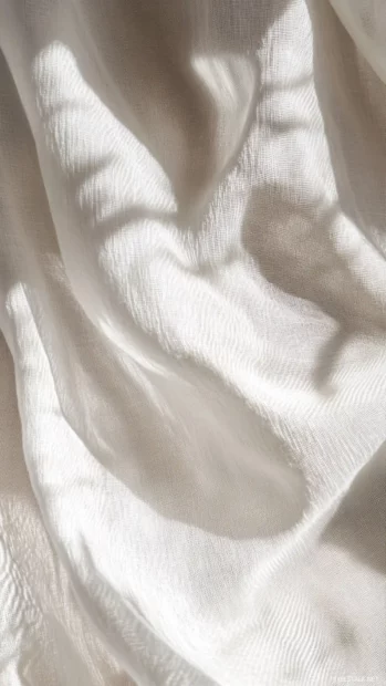 Faint shadow patterns cast across light fabric textures.