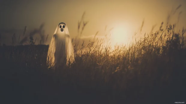 Ghost outlined in vintage grain floating across twilight field.
