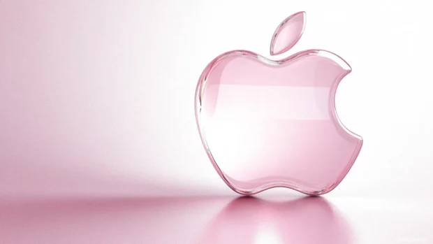High detail Apple logo reflecting soft pastel colors on smooth background.