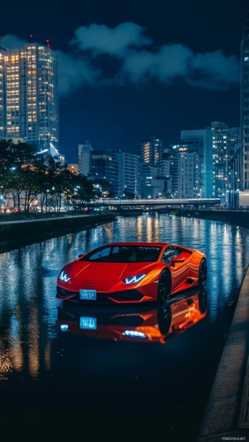 Lamborghini driving beside a reflective river during blue hour.