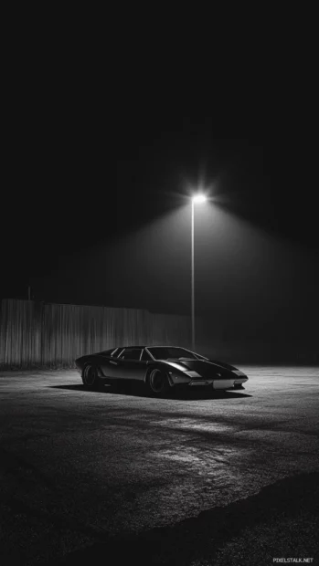 Lamborghini under a spotlight in an abandoned parking lot at night.