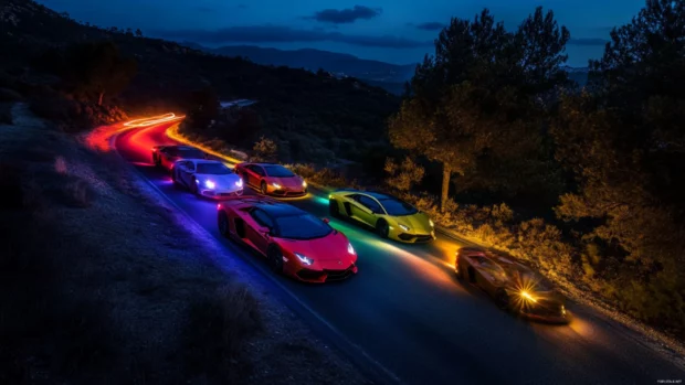 Long exposure photo of Lamborghini trails glowing in different colors on a dark country road.