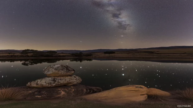 Night scene serene, vibrant starry sky above calm lake, stars reflecting water perfectly, peaceful enchanting atmosphere.