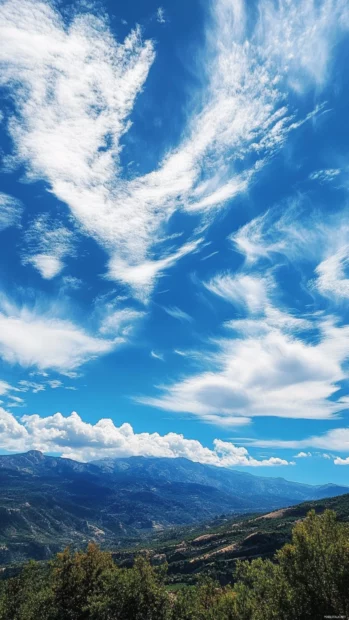 Pretty clouds drifting over blue mountains.