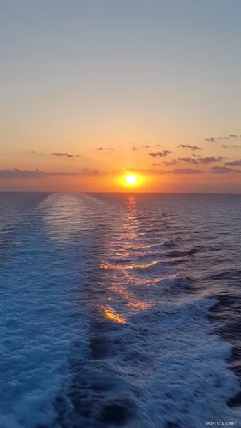Pretty sunrise lighting up calm ocean horizon.