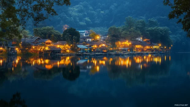 Reflections of a pretty village glowing in a tranquil lake.