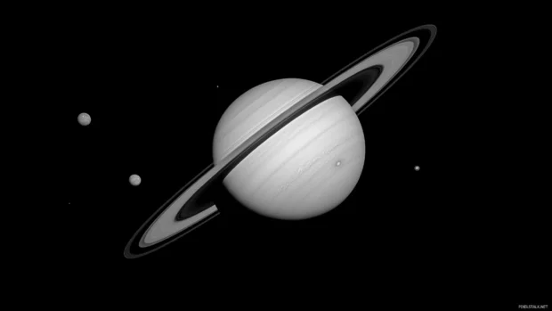 Ringed planet Saturn casting shadow over its moons.