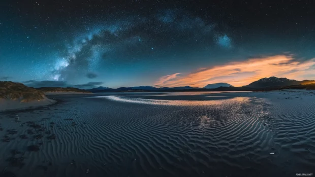 Rippling dunes basking in black starry twilight.