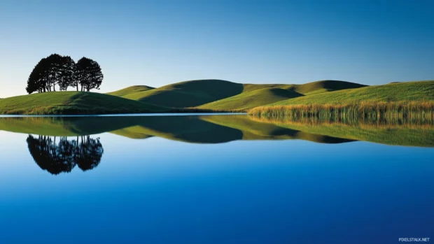 Rolling hills reflected in a crystal blue lake, ideal for Sunset scenery wallpaper for desktop.