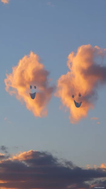 Silly ghost faces morph into clouds that drift through a warm evening sky.
