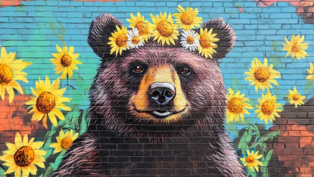 Smiling bear painted with daisy crowns along street mural.