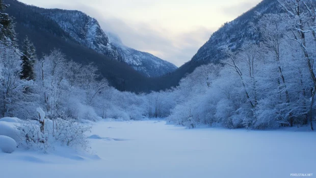 Snowy mountain scenery desktop wallpaper featuring a valley blanketed by soft winter snow.
