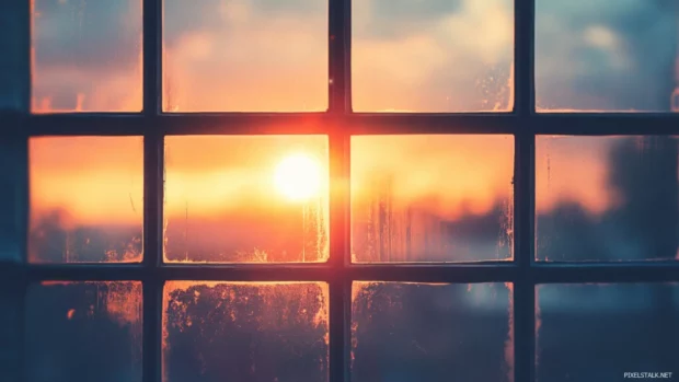 Sunset viewed through windowpane styled in retro grain.