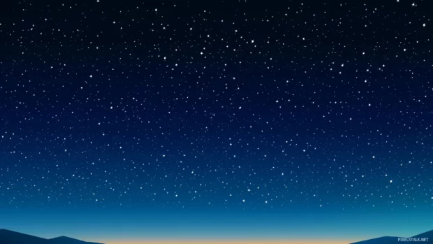 Thousands of twinkling stars spread across a deep blue and black gradient create a breathtaking starry sky where the Milky Way is clearly visible in the distance.